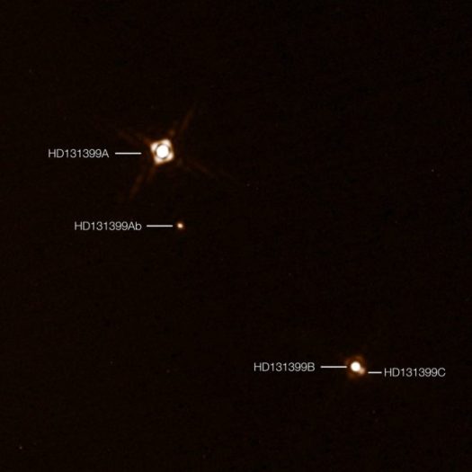 This annotated composite image shows the newly discovered exoplanet HD 131399Ab in the triple-star system HD 131399. The image of the planet was obtained with the SPHERE imager on the ESO Very Large Telescope in Chile. This is the first exoplanet to be discovered by SPHERE and one of very few directly-imaged planets. With a temperature of around 580 degrees Celsius and an estimated mass of four Jupiter masses, it is also one of the coldest and least massive directly-imaged exoplanets. This picture was created from two separate SPHERE observations: one to image the three stars and one to detect the faint planet. The planet appears vastly brighter in this image than in would in reality in comparison to the stars.