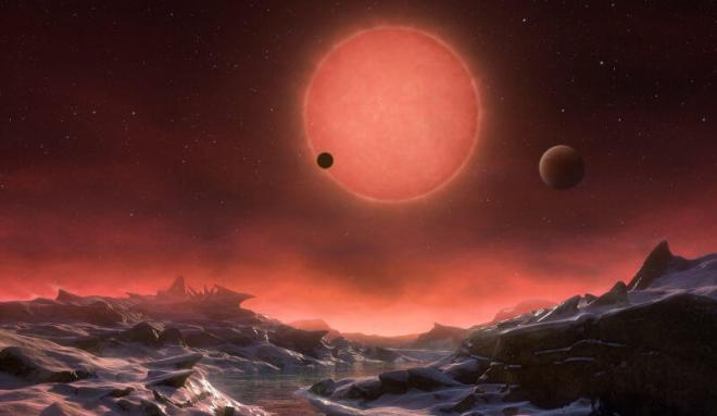 This artist’s impression shows an imagined view from the surface one of the three planets orbiting an ultracool dwarf star just 40 light-years from Earth that were discovered using the TRAPPIST telescope at ESO’s La Silla Observatory. (M. Kornmesser/ESO)